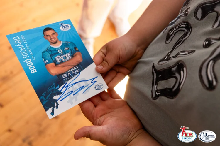 Gyerek két kézzel tartja az aláírt PICK Szeged autogramkártyát a találkozó végén, közelről fotózva