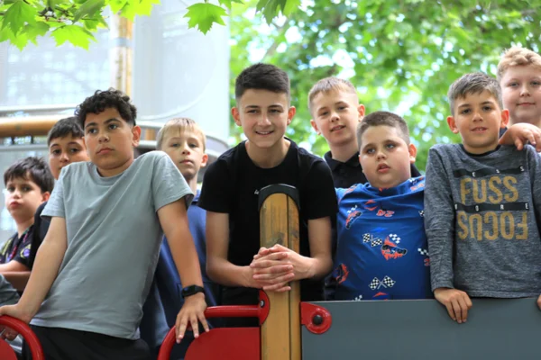 A Sugó Tamburazenekar gyerektagjai együtt állnak a Szent István park játszóterének mászókáján.