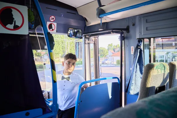 Fehér inges fiú a busz ajtajában áll, indulás közben a révfülöpi Duna TV-s fellépés előtt.