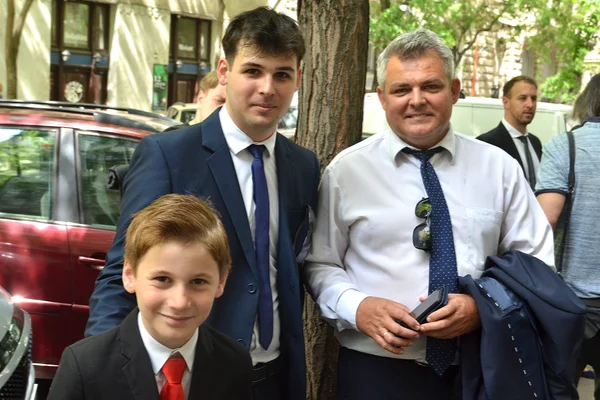 A Sugó Tamburazenekar vezetője két fiúval áll a budapesti utcán, az országgyűlési fellépés napján.