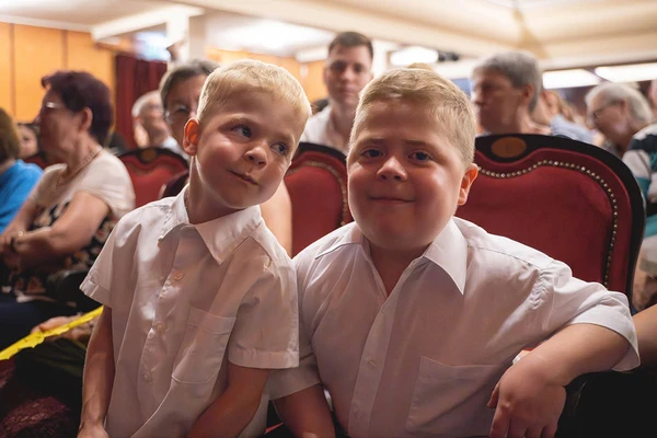 Két kisfiú a városi színházteremben, akikért a Gyermekek a gyermekekért jótékonysági koncertet rendezték